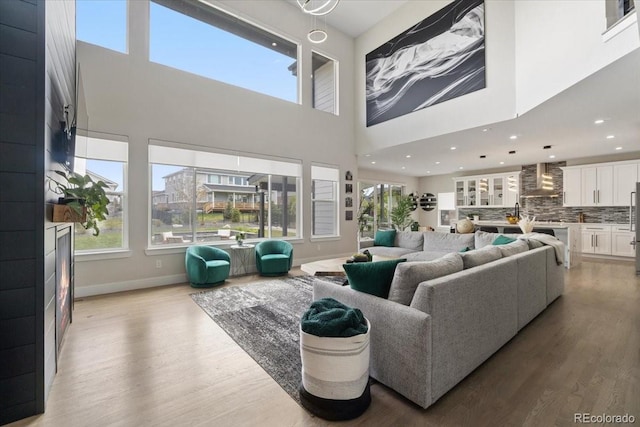 27250 E Nova Cir, Aurora, CO 80016 - living room featuring light wood-style floors, a high ceiling, baseboards, and recessed lighting