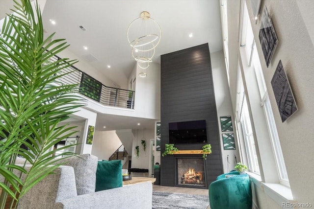 27250 E Nova Cir, Aurora, CO 80016 - living room with a towering ceiling, a fireplace, wood finished floors, and stairs
