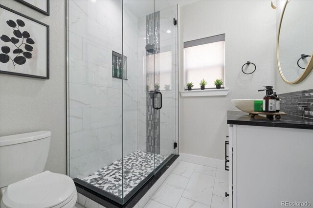 27250 E Nova Cir, Aurora, CO 80016 - full bath featuring marble finish flooring, toilet, a stall shower, vanity, and baseboards