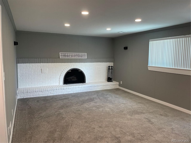 unfurnished living room with carpet flooring, a fireplace, and crown molding