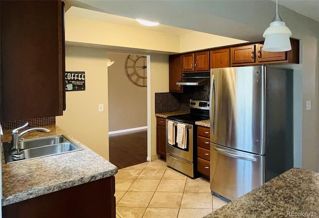 kitchen with appliances with stainless steel finishes, backsplash, light tile patterned floors, decorative light fixtures, and sink