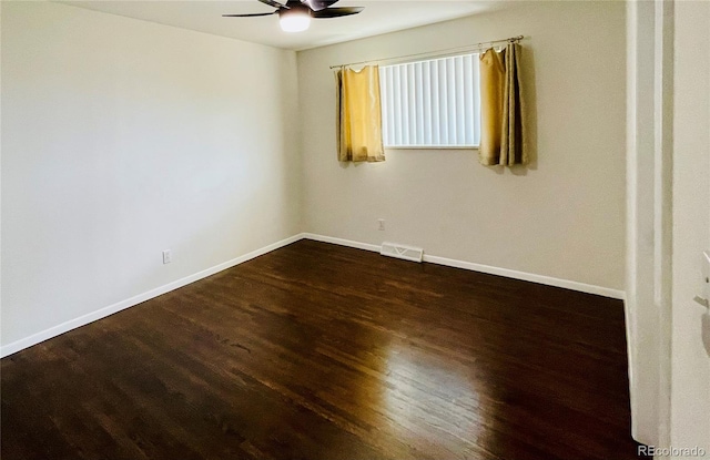 spare room with dark hardwood / wood-style flooring and ceiling fan