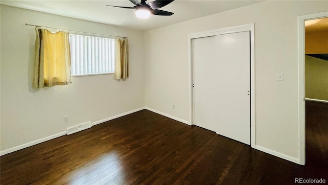 unfurnished bedroom featuring a closet, ceiling fan, and dark hardwood / wood-style flooring