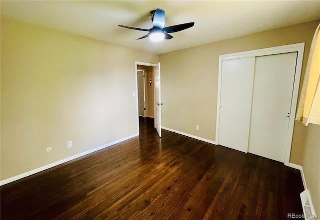 unfurnished bedroom with dark hardwood / wood-style flooring, ceiling fan, and a closet