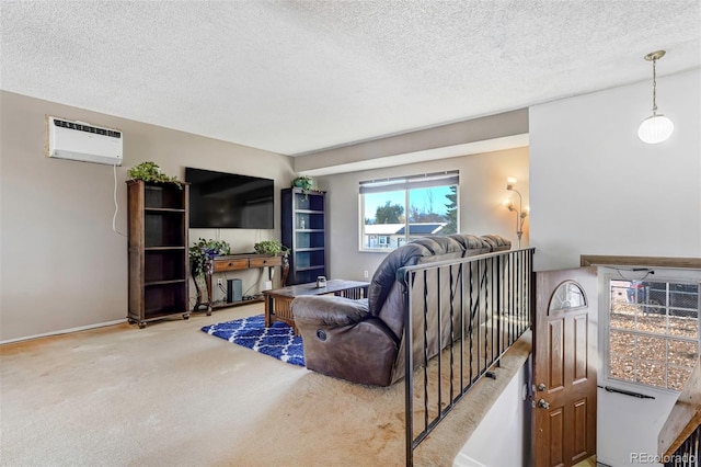 living room featuring a wall unit AC, carpet floors, and a textured ceiling