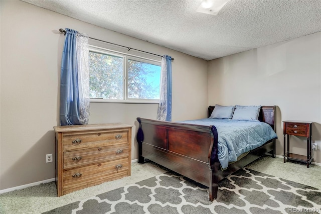 bedroom featuring light carpet and a textured ceiling