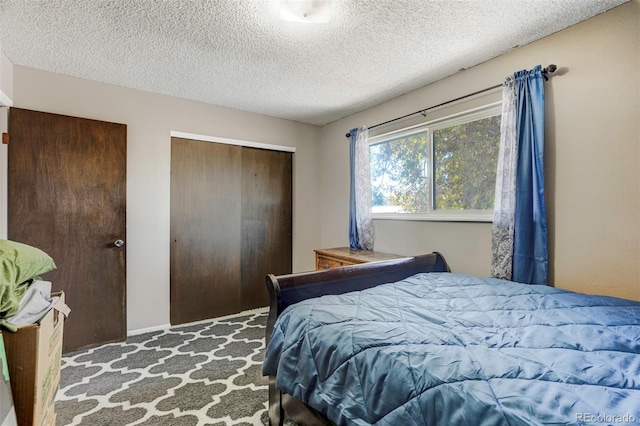 carpeted bedroom with a textured ceiling and a closet