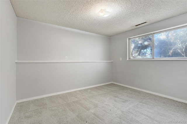 carpeted spare room with a textured ceiling