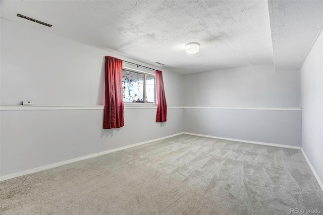 unfurnished room with carpet and a textured ceiling