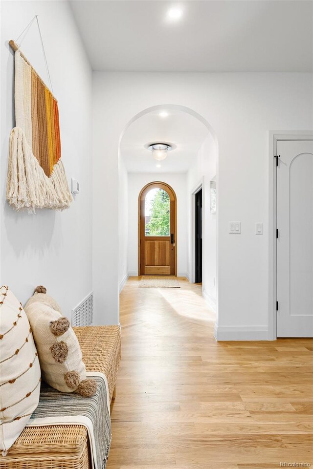 659 Albion St, Denver, CO 80220 - entrance foyer featuring arched walkways, light wood-style flooring, and baseboards