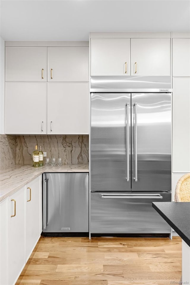 659 Albion St, Denver, CO 80220 - kitchen featuring built in refrigerator, white cabinetry, and fridge