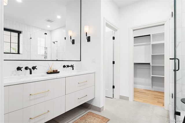 659 Albion St, Denver, CO 80220 - bathroom featuring a shower stall, double vanity, a walk in closet, recessed lighting, and baseboards