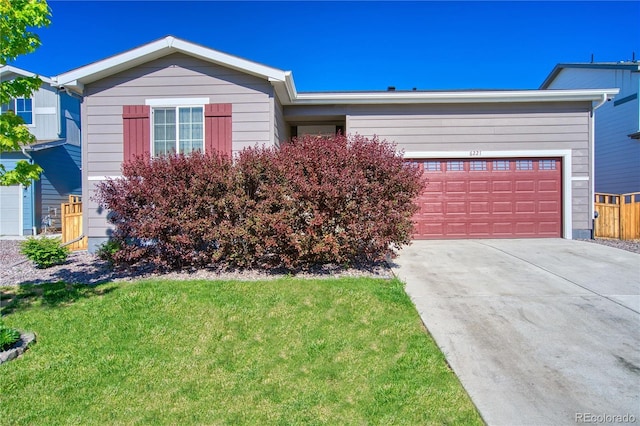 view of front of home featuring concrete driveway, a front lawn, and an attached garage