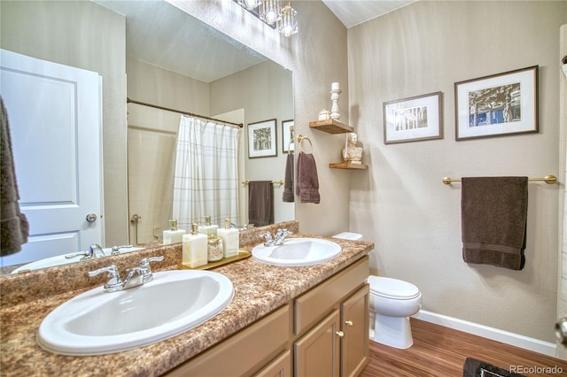 full bath featuring wood finished floors, toilet, baseboards, curtained shower, and double vanity