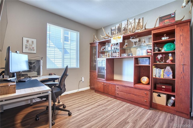 office with light wood-style flooring and baseboards