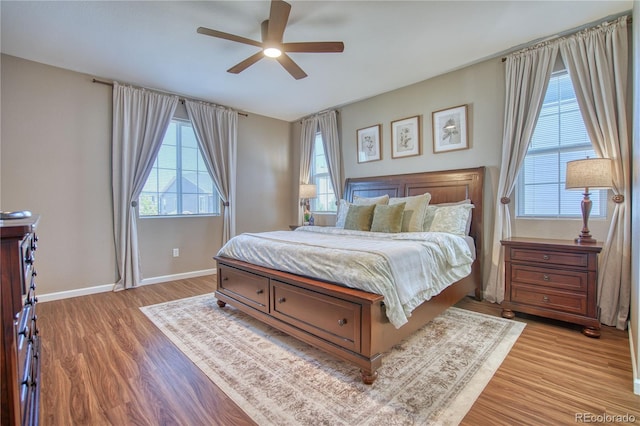 bedroom featuring light wood-style floors, baseboards, and a ceiling fan