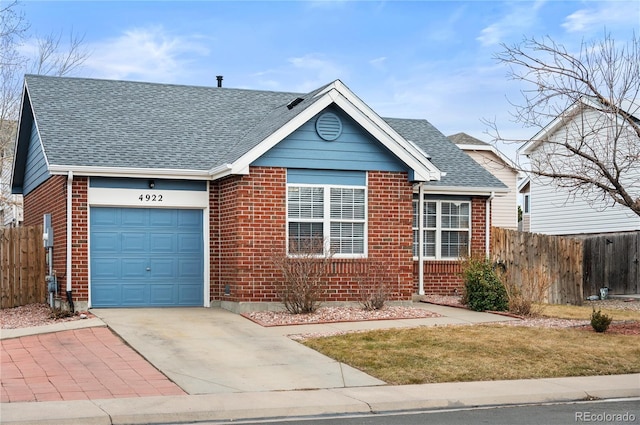 ranch-style home with brick siding, a shingled roof, concrete driveway, an attached garage, and fence