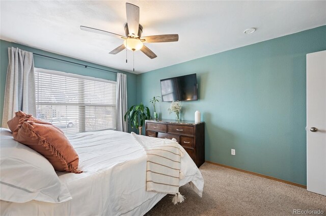 bedroom with light carpet, ceiling fan, and baseboards