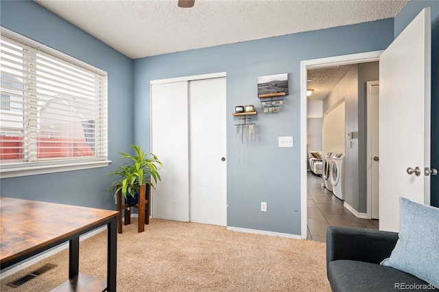 carpeted office space with washer and dryer, visible vents, and a textured ceiling