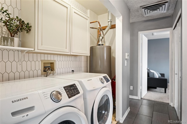 laundry room featuring cabinet space, visible vents, water heater, washer and dryer, and baseboards