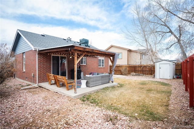 back of house with a patio, a fenced backyard, an outdoor hangout area, a shed, and brick siding