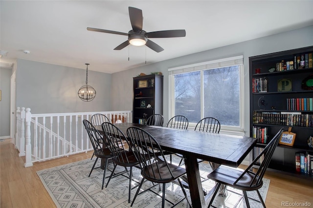 dining room with light wood-type flooring and an inviting chandelier