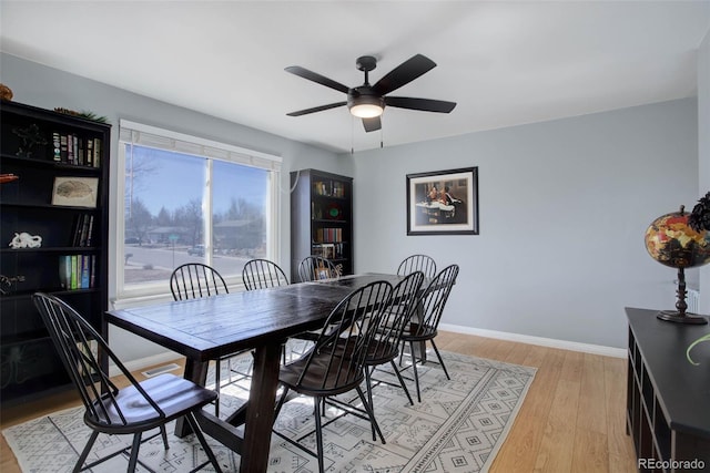 dining space featuring ceiling fan, light wood-style flooring, and baseboards