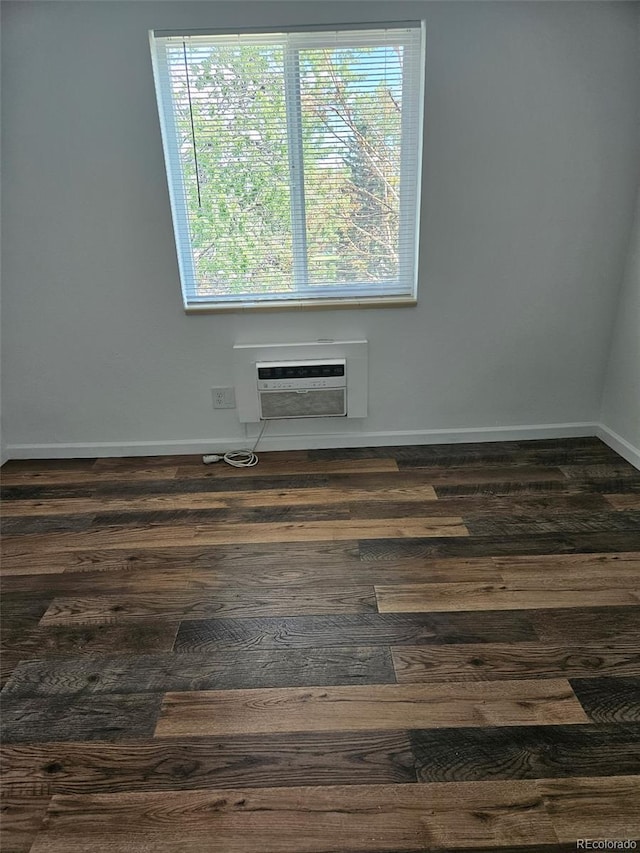 1304 S Parker Rd Unit 13, Denver, CO 80231 - empty room featuring baseboards, dark wood-style flooring, and an AC wall unit