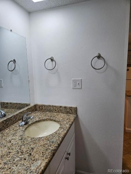 1304 S Parker Rd Unit 13, Denver, CO 80231 - bathroom with vanity and a textured ceiling