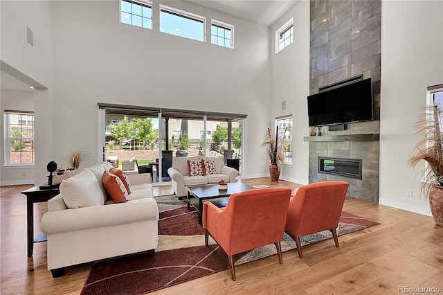 6639 S Vandriver Way, Aurora, CO 80016 - living area featuring a high ceiling, a tiled fireplace, and wood finished floors