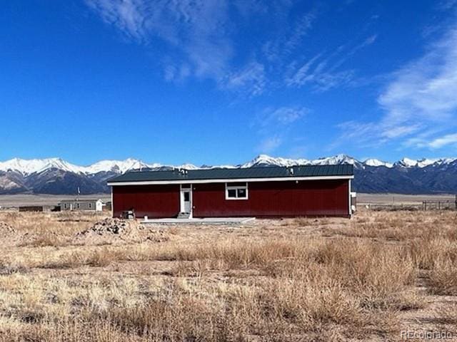 back of house featuring a mountain view and a rural view