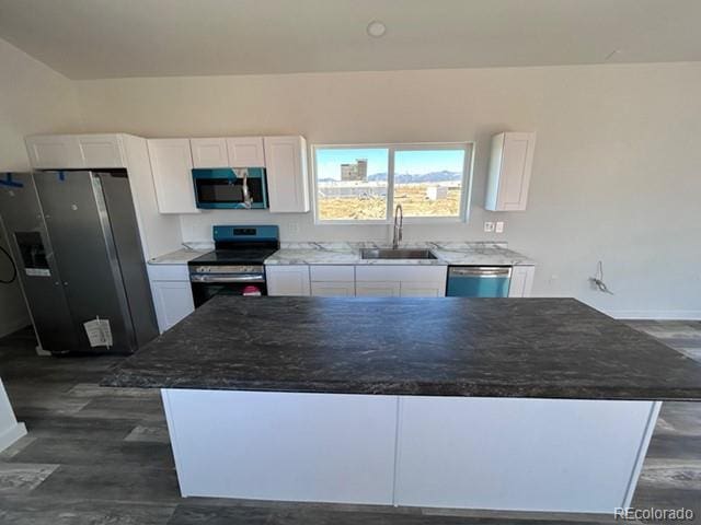 kitchen featuring white cabinetry, sink, dark hardwood / wood-style floors, a kitchen island, and appliances with stainless steel finishes