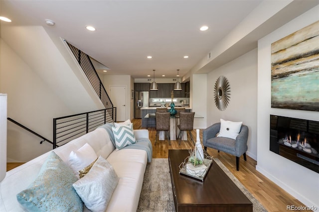 3408 W 18th Ave, Denver, CO 80204 - living room featuring light wood finished floors, recessed lighting, a glass covered fireplace, and stairway