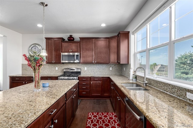 27029 E Irish Pl, Aurora, CO 80016 - kitchen with a sink, stainless steel appliances, dark wood finished floors, light stone countertops, and decorative backsplash