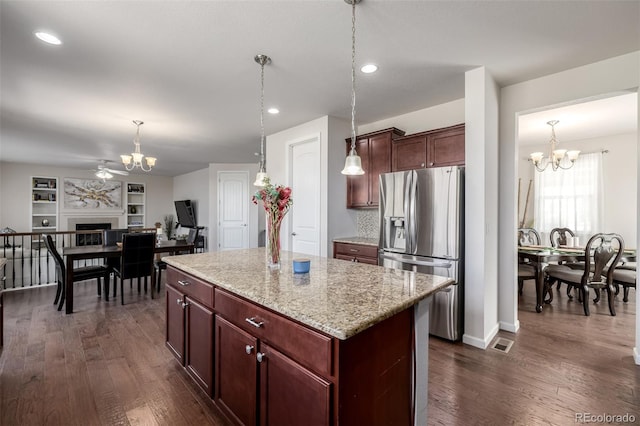 27029 E Irish Pl, Aurora, CO 80016 - kitchen featuring stainless steel fridge, a chandelier, a kitchen island, dark wood finished floors, and recessed lighting