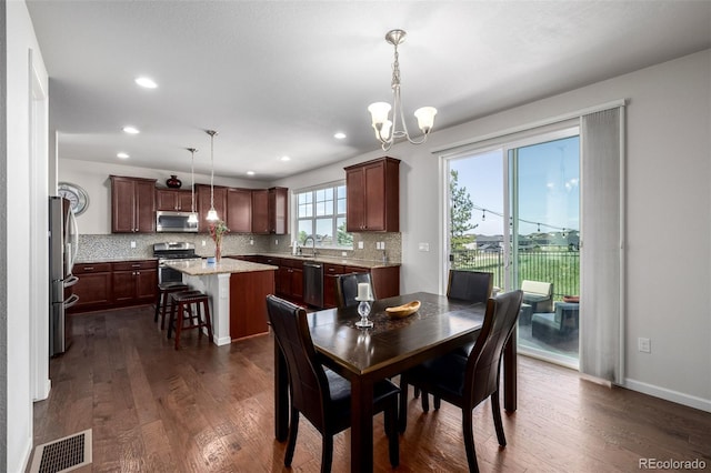 27029 E Irish Pl, Aurora, CO 80016 - dining space featuring dark wood-style flooring, a chandelier, recessed lighting, and baseboards