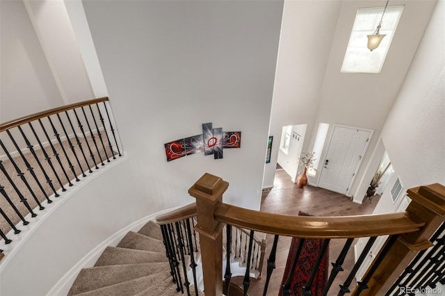 27029 E Irish Pl, Aurora, CO 80016 - staircase with a high ceiling, wood finished floors, and baseboards