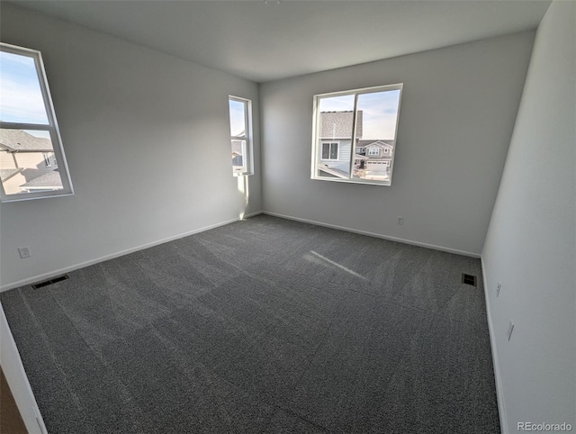 unfurnished room with dark colored carpet