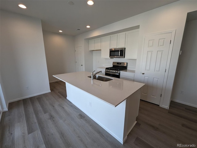 kitchen with a center island with sink, white cabinets, sink, and appliances with stainless steel finishes