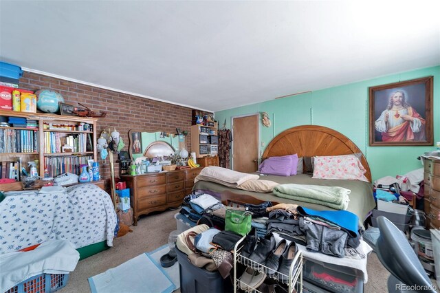 bedroom with carpet floors and brick wall