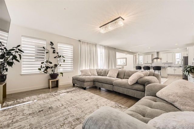 living room with a chandelier, light hardwood / wood-style flooring, and a wealth of natural light