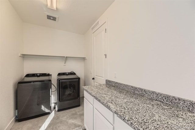 clothes washing area featuring light tile patterned floors and independent washer and dryer