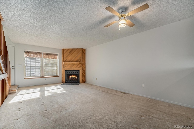 unfurnished living room with a fireplace, light colored carpet, a textured ceiling, and ceiling fan