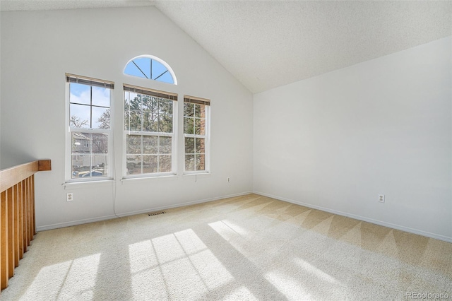 carpeted spare room featuring a textured ceiling and vaulted ceiling