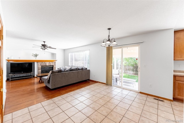 13180 Jasmine St, Thornton, CO 80602 - living area featuring plenty of natural light, a glass covered fireplace, a chandelier, and light tile patterned flooring