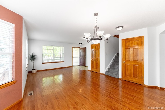 13180 Jasmine St, Thornton, CO 80602 - unfurnished room with a chandelier, wood finished floors, baseboards, and stairway