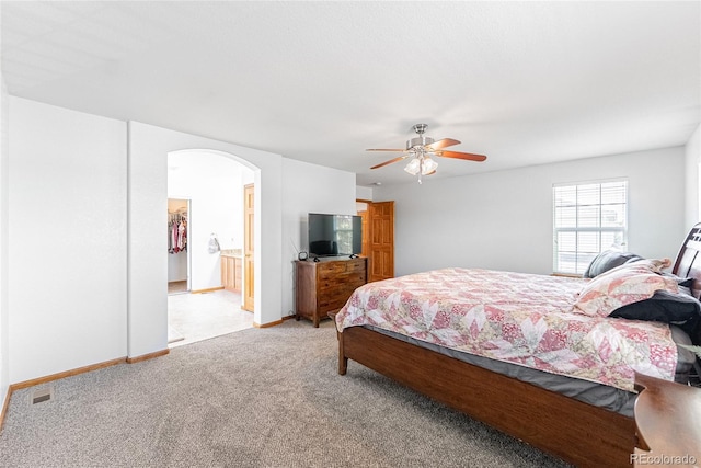 13180 Jasmine St, Thornton, CO 80602 - bedroom featuring arched walkways, light colored carpet, a ceiling fan, baseboards, and ensuite bath