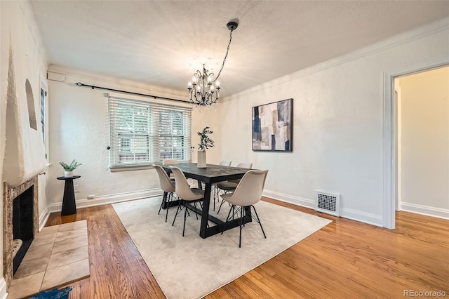 dining room featuring a notable chandelier, visible vents, baseboards, and light wood-type flooring