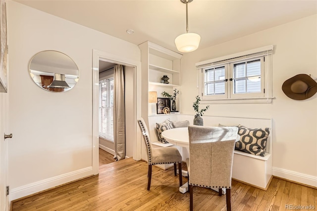 dining area with baseboards and light wood-type flooring