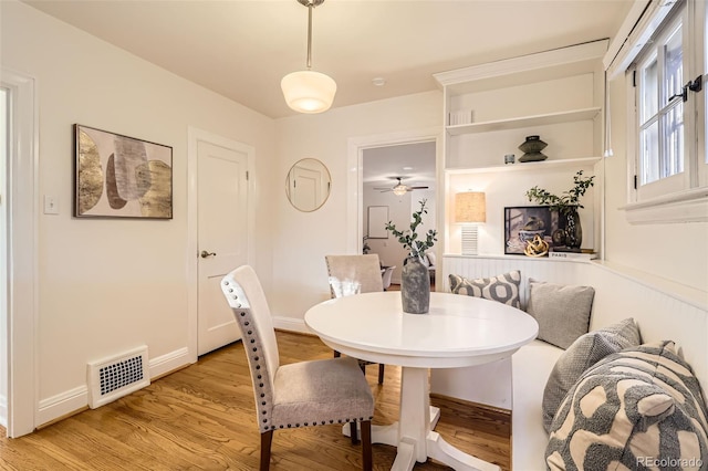 dining area with visible vents, light wood-style floors, and ceiling fan